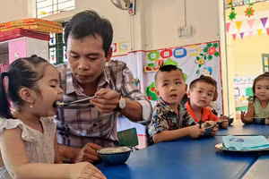 Thầy giáo Trường Mầm non Thành Sơn (Bá Thước, Thanh Hóa) cho trẻ ăn trưa tại trường.