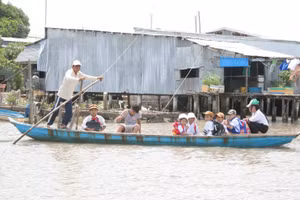 Học sinh huyện Ngọc Hiển (Cà Mau) đến trường bằng đò. Ảnh: Q. Ngữ