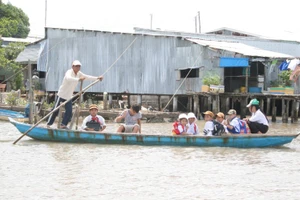 Học sinh huyện Ngọc Hiển (Cà Mau) đến trường bằng đò. Ảnh: Q. Ngữ