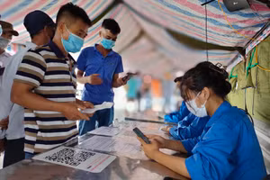 Lê Thị Lan (bên phải) hướng dẫn người dân khai báo y tế.