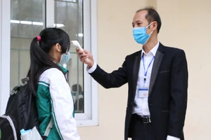 Các học sinh trường THCS ở huyện Ba Vì được đo thân nhiệt, sát khuẩn tay trước khi vào lớp ngày 8/11. Ảnh: Đình Tuệ