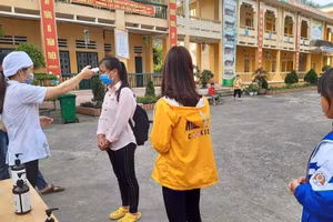 Đo thân nhiệt và khử khuẩn tay trước khi vào lớp tại Trường PTDTNT THCS & THPT huyện Si Mai Cai (Lào Cai) sáng 4/5. Ảnh: NTCC