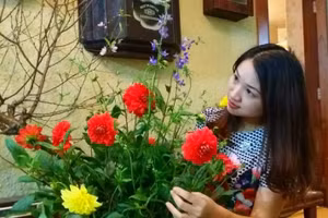 Nhà thơ, nhà báo Lữ Mai bên lọ hoa, cành đào đậm hương vị Tết cổ truyền.