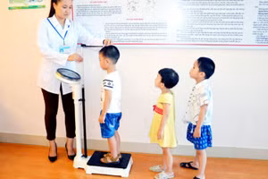 Nhân viên y tế kiểm tra sức khỏe cho trẻ mầm non tại trường. Ảnh: IT