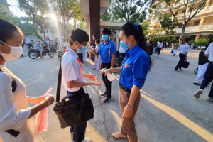 Học sinh lớp 9 tại TP Mỹ Tho (Tiền Giang) đến trường ôn thi được đo nhiệt độ và sát khuẩn tay 