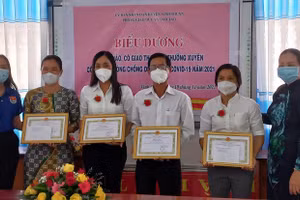 Cô Huỳnh Thị Mai Anh (thứ 3 từ trái sang) nhận Giấy khen vì thành tích xuất sắc trong tham gia phòng chống dịch.