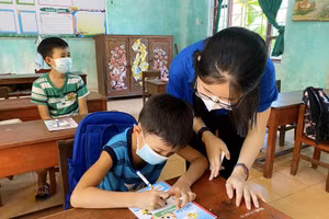 Cô giáo “áo xanh” ở Triệu Phong hướng dẫn học sinh học phụ đạo hè. Ảnh: TG