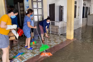 Giáo viên huyện Quỳnh Lưu dọn dẹp vệ sinh trường lớp khi nước bắt đầu rút.