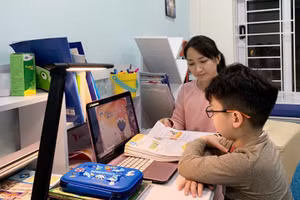Phụ huynh hỗ trợ học sinh học trực tuyến. Ảnh: Internet