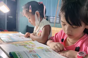 Giáo viên chong đèn dạy con chữ cho các em học sinh.