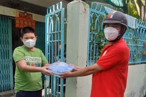 Giáo viên tại Quận 8, TPHCM mang sách đến nhà cho học sinh.