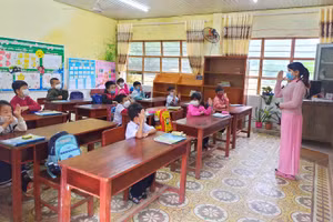 Học sinh lớp Một được cô giáo hướng dẫn nền nếp hoạt động tại lớp trong buổi học đầu tiên. 