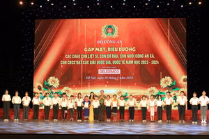 Thứ trưởng điều hành Bộ Công an Trần Quốc Tỏ và Phó Chủ tịch Hội Liên hiệp Phụ nữ Việt Nam Tôn Ngọc Hạnh trao thưởng cho các học sinh.