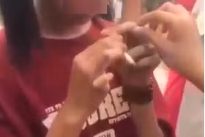 Hình ảnh nữ sinh bị ép hút thuốc lá.