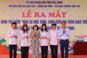 Chủ tịch UBND tỉnh Bắc Ninh - Nguyễn Hương Giang và Giám đốc Sở GDĐT Bắc Ninh Nguyễn Thế Sơn trao mũ bảo hiểm cho học sinh.