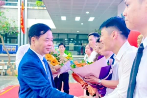 Ông Đoàn Tiến Trung - phó Trưởng phòng GD&ĐT quận Cầu Giấy tặng hoa thí sinh dự thi.