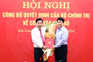 Thường trực Ban Bí thư Lương Cường (phải) trao quyết định và tặng hoa chúc mừng Trung tướng Nguyễn Văn Gấu. (Ảnh: BBG)