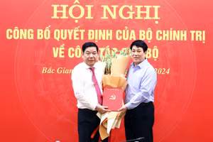 Thường trực Ban Bí thư Lương Cường (phải) trao quyết định và tặng hoa chúc mừng Trung tướng Nguyễn Văn Gấu. (Ảnh: BBG)