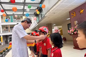 Bí thư Quận uỷ Ba Đình, Hoàng Minh Dũng Tiến đội mũ bảo hiểm cho học sinh trường Tiểu học Kim Đồng.