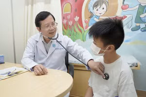 TS.BS. Nguyễn Huy Luân khám, tư vấn cho trẻ trước khi tiêm chủng. (Ảnh: BVCC)