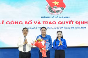 Bà Nguyễn Phạm Duy Trang trao quyết định và ông Nguyễn Phước Lộc tặng hoa chúc mừng anh Ngô Minh Hải, Bí thư Thành Đoàn TPHCM.