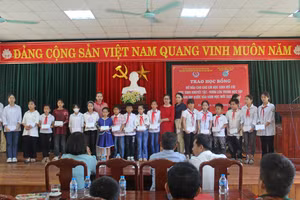 Gia đình tiến sĩ Lê Xuân Thảo, Lê Bích Thắng trao học bổng đỡ đầu cả năm cho 20 học sinh mồ côi, có hoàn cảnh khó khăn. Ảnh: LT.