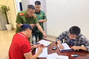 Lê Văn Nam (áo sọc) tại cơ quan công an. Ảnh: CATH.