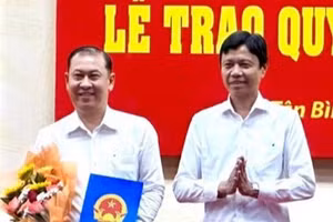 Ông Nguyễn Bá Thành, chủ tịch UBND quận Tân Bình trao quyết định bổ nhiệm Trưởng phòng GD&ĐT cho ông Phan Văn Quang (trái). Ảnh: GIA HUY.