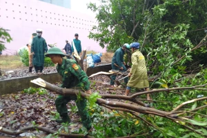 Cán bộ, chiến sĩ Đồn Biên phòng Vĩnh Châu cùng các lực lượng giúp dân khắc phục hậu quả dông lốc.