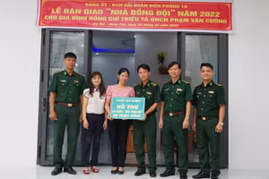 Trung tá Nguyễn Văn Chung, Chủ nhiệm Chính trị Hải đoàn Biên phòng 18 trao bảng tượng trưng hỗ trợ “Nhà đồng đội” cho gia đình Thiếu tá Phạm Văn Cường. 