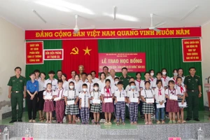 Đại diện lãnh đạo BĐBP tỉnh và Hội khuyến học tỉnh, chính quyền địa phương và nhà trường chụp hình lưu niệm với các em học sinh. 