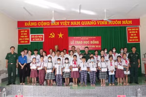 Đại diện lãnh đạo BĐBP tỉnh và Hội khuyến học tỉnh, chính quyền địa phương và nhà trường chụp hình lưu niệm với các em học sinh. 
