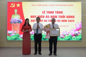 Trưởng Ban Tổ chức Thành ủy TPHCM Nguyễn Phước Lộc và Phó Bí thư Đảng uỷ khối ĐH, CĐ Nguyễn Thị Là trao Huy hiệu Đảng cho đảng viên tại buổi lễ.