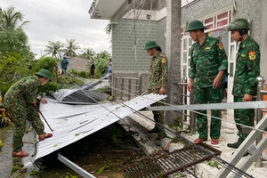 Cán bộ, chiến sĩ Đồn Biên phòng Trung Bình giúp người dân khắc phục hậu quả thiên tai.