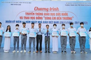 Ông Vũ Anh Tuấn, Vụ trưởng, trưởng Cơ quan thường trực Ban Dân vận trung ương tại TPHCM và Tiến sĩ, bác sĩ Nguyễn Nam Hà, Trưởng Chi hội Truyền thông Giáo dục Sức khỏe, Hội Y tế Công cộng TP trao học bổng cho các em học sinh.