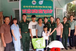 Đại diện lãnh đạo các đơn vị và địa phương chụp hình lưu niệm với gia đình cháu Sơn Ngọc Mít. Ảnh : Hoàng Đoán.