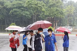 Mưa như trút các thí sinh ở Sơn La được bố mẹ che ô đưa đến điểm trường thi tốt nghiệp.