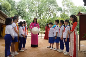 Học sinh Trường Tiểu học Hoàng Trù (xã Kim Liên, Nam Đàn, Nghệ An) đến thăm quê nội Bác Hồ và lắng nghe cô thuyết minh kể chuyện về gia đình Người.