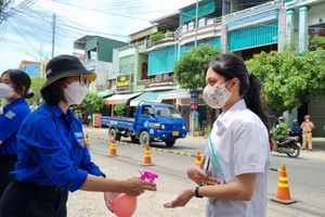 Thí sinh sát khuẩn trước khi vào phòng thi tại điểm thi trường THPT chuyên Lê Khiết.