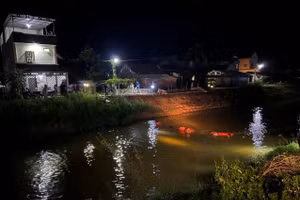 Lực lượng chức năng và người dân tìm kiếm nạn nhân xuyên đêm trên đoạn kênh hai anh em gặp nạn. Ảnh PNTĐ