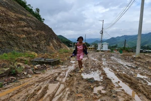 Bà Xuân cõng cháu đi học về. 