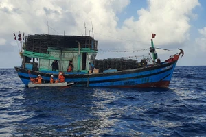 Tàu cứu nạn tiếp cận tàu cá để cứu người bị thương. 