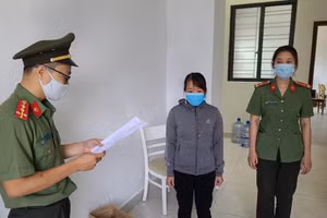 Công an tống đạt quyết định khởi tố vụ án, khởi tố bị can đối với Nguyễn Thị Kim Anh. Ảnh: Công an. 