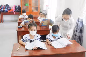 Cô giáo kiểm tra sách vở, đồ dùng học tập, tư thế ngồi, cách cầm bút và khảo sát kiến thức HS nắm được sau thời gian học trực tuyến. Ảnh: Hà Nguyên 