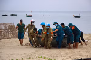 Lực lượng dân phòng cùng dân quân tự vệ hỗ trợ di chuyển thuyền thúng của người dân lên bờ. 