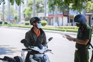 Lực lượng công an kiểm tra giấy đi đường của người dân. 
