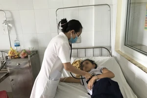 Bác sĩ khám cho một học sinh đang nhập viện. 