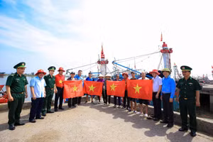 Báo Người lao động phối hợp với các Ban, ngành trao cờ Tổ quốc đến ngư dân bám biển. (Ảnh: TM).