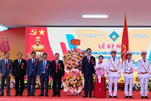 Ông Lê Đức Giang, Phó Chủ tịch UBND tỉnh Thanh Hoá tặng hoa chúc mừng Nhà trường và gia đình hậu duệ nhà giáo Lê Xuân Lan. (Ảnh: NT)