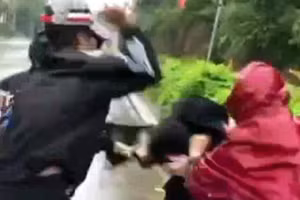 Hai học sinh tham gia đánh hội đồng một người phụ nữ. (Ảnh: Cắt từ clip).